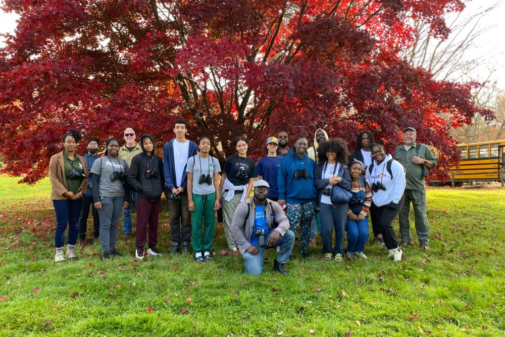 Group photo in front of a tree with foliage in Autumn