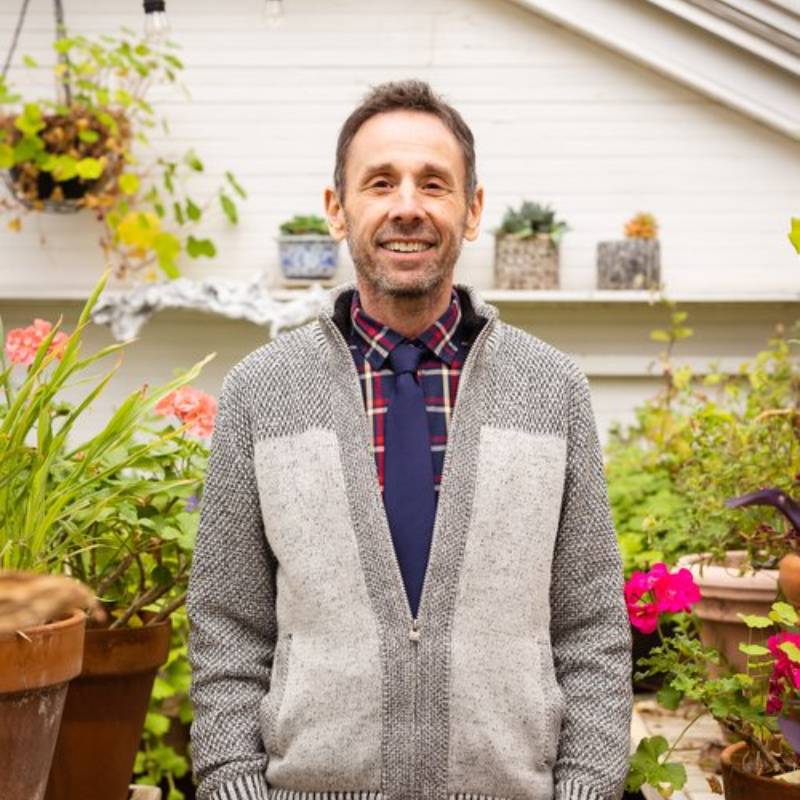 Man smiling in front of plants