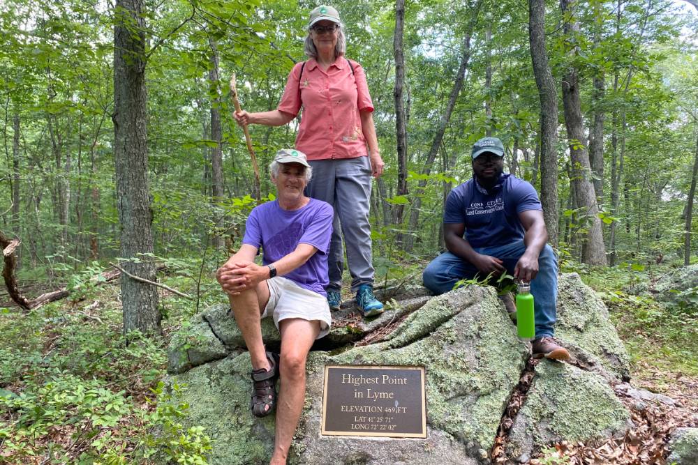 Group photo at a plaque at a preserve