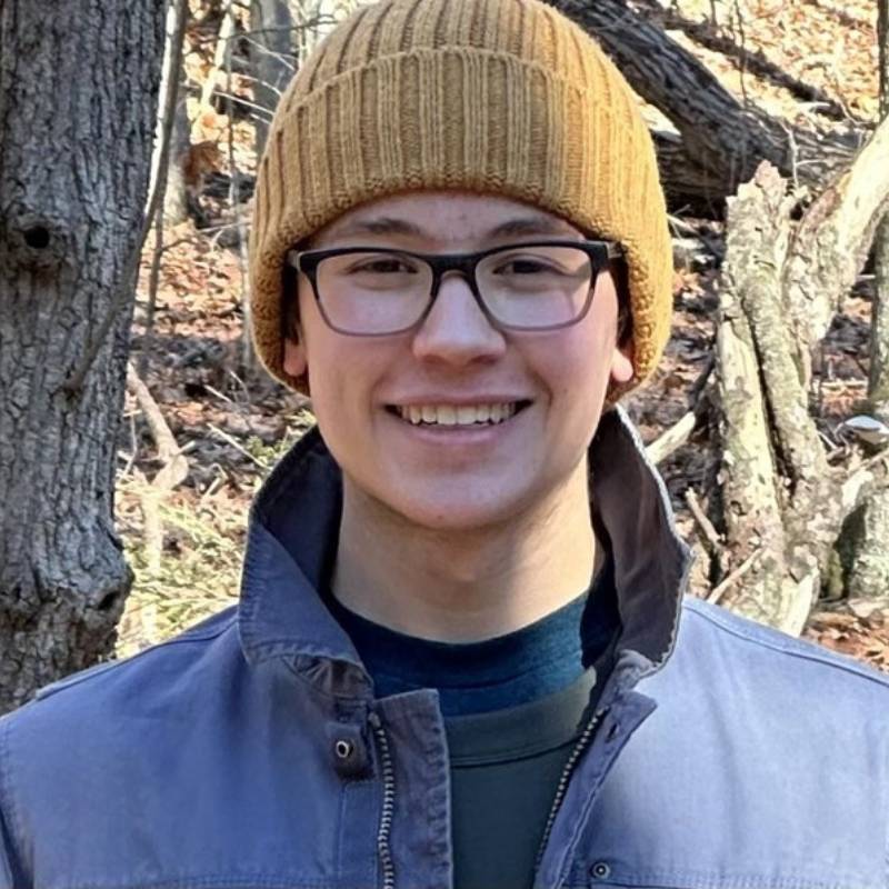 Young man in a hat outside in the woods