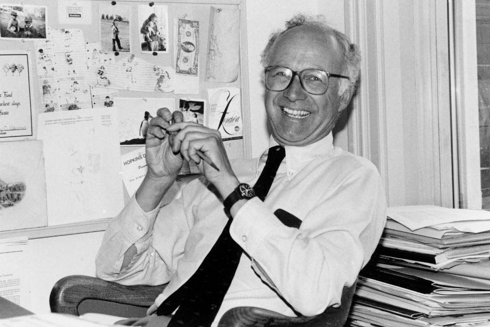 Black and white photo of Peter Cooper smiling at a desk