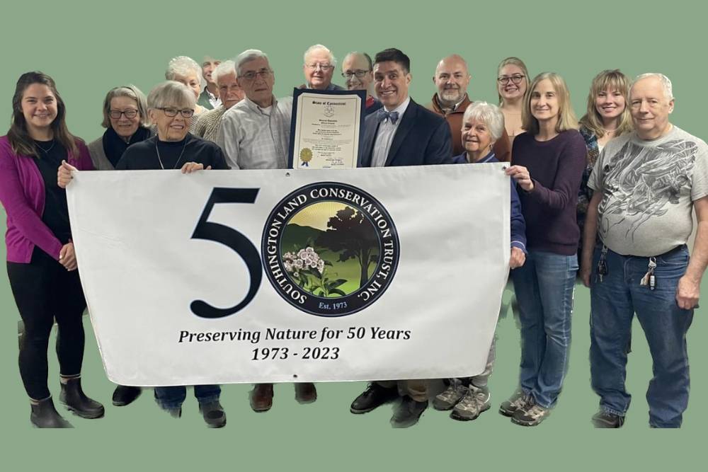 Group photo holding a 50th anniversary banner
