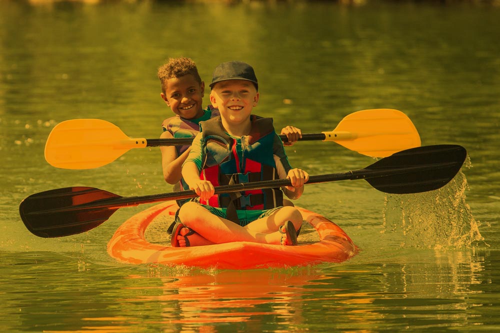 two kids kayaking on the river
